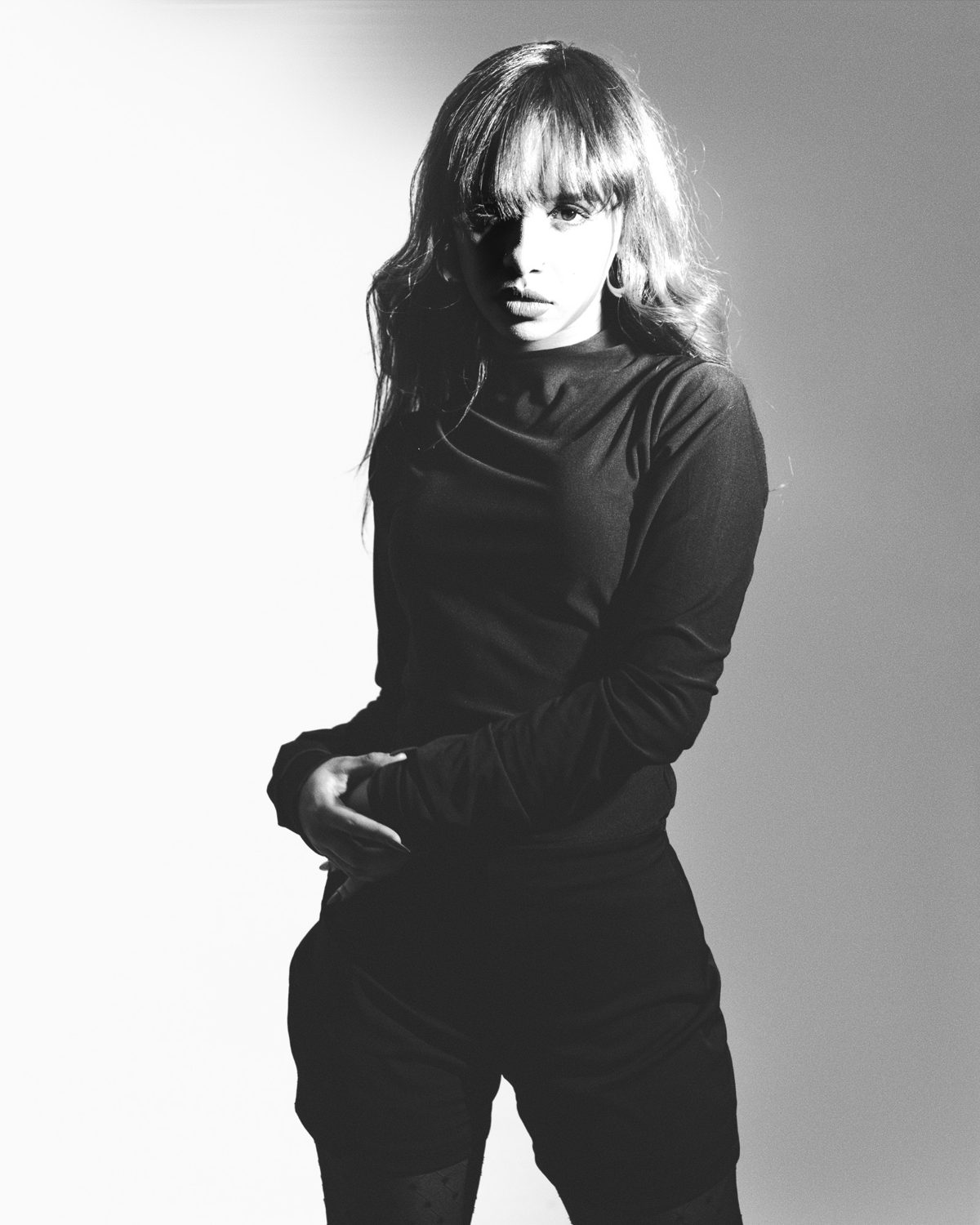 Melat backlit against a grey studio wall